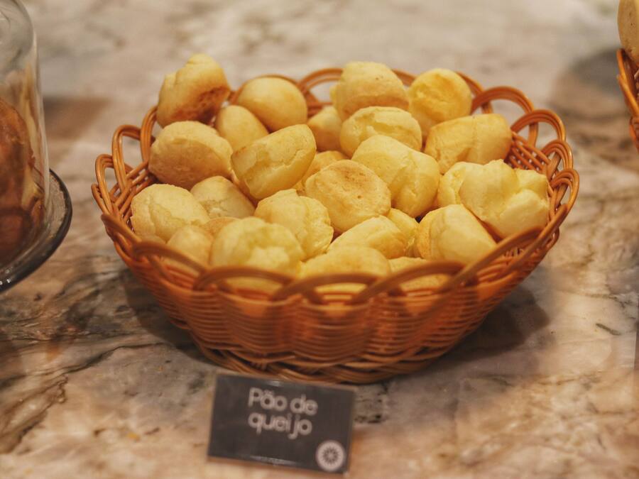 Eine Schale mit Pão de Queijo auf einer Marmorplatte.