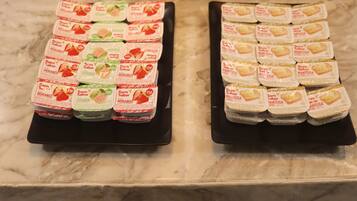 Deux plateaux contenant des aliments emballés, posés sur un comptoir en marbre.