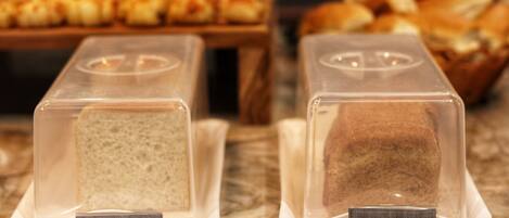 Two bread display cases labeled "Pão natural" and "Pão integral" on a marble countertop.