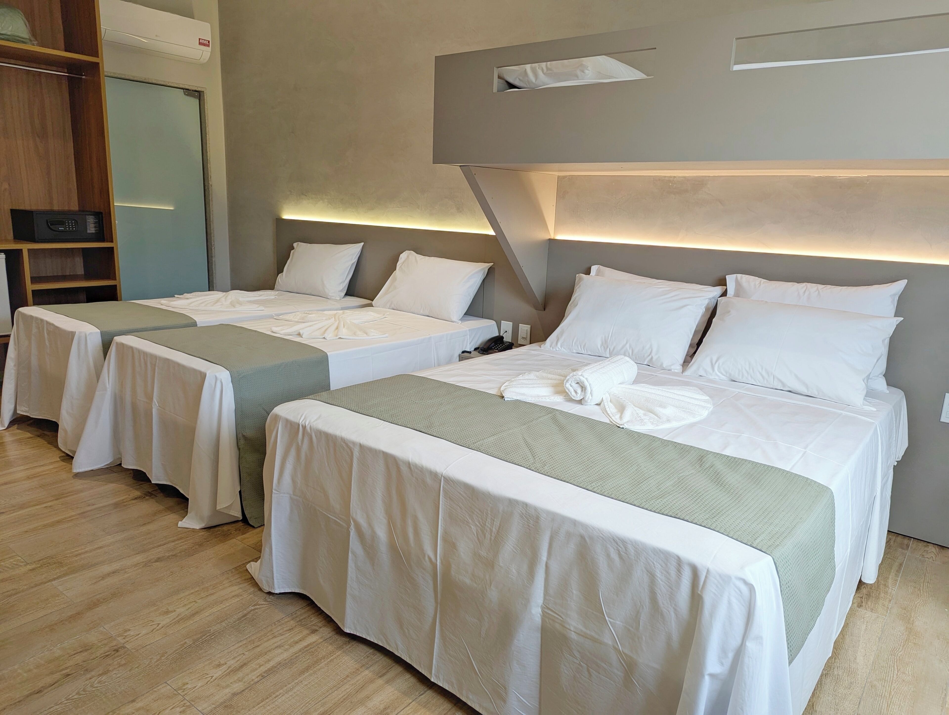 Una habitación de hotel con dos camas individuales, un escritorio y un armario.