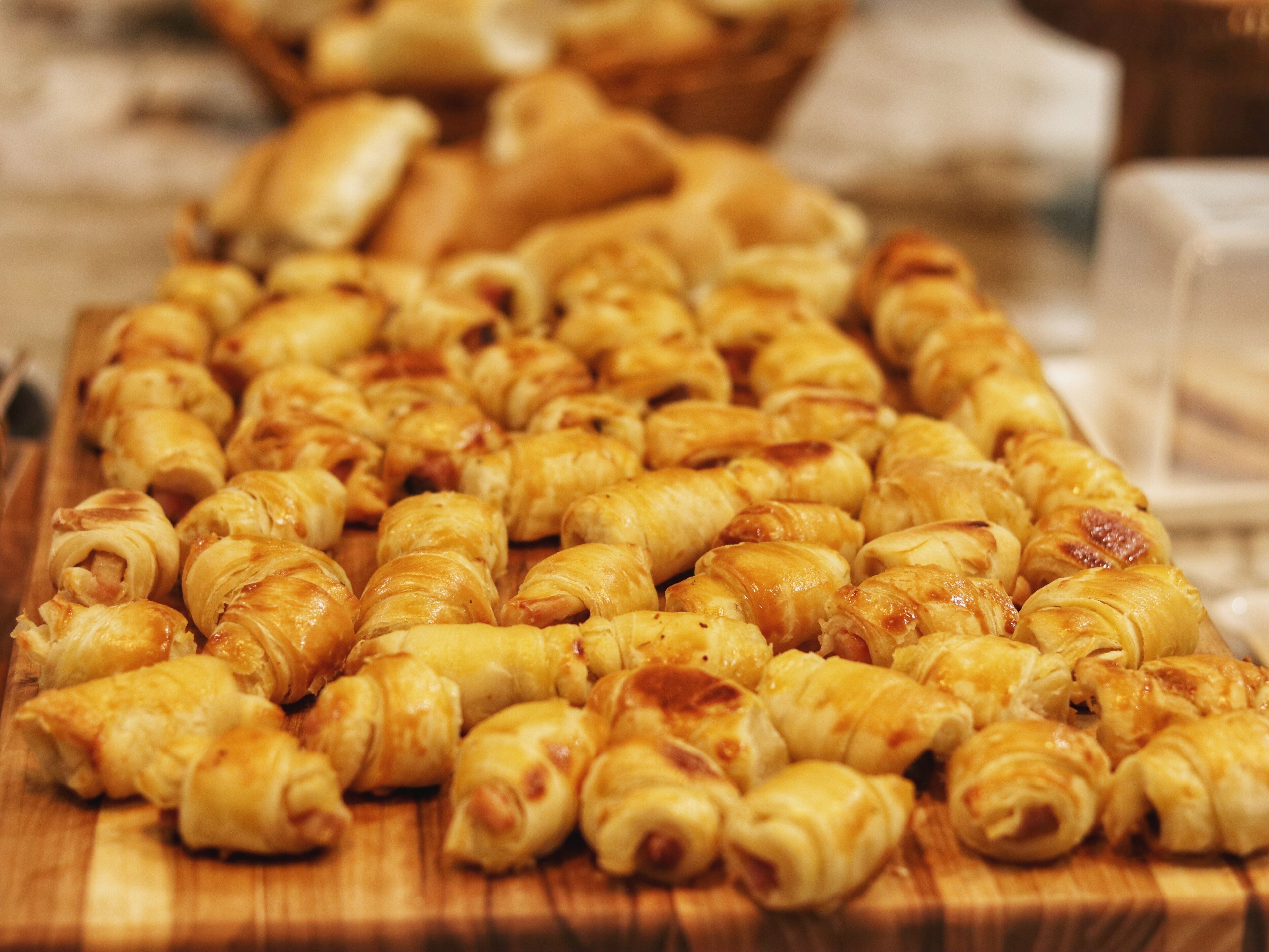 A wooden cutting board with neatly arranged pastries.