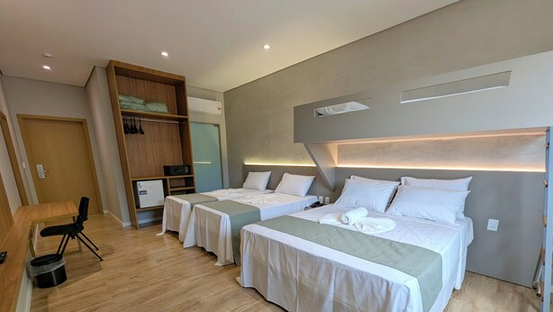 Een hotelkamer met twee bedden, een bureau, een stoel en een kledingkast.