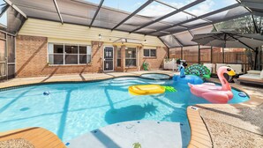 Une piscine intérieure dotée d’un patio couvert, d’un jacuzzi et de jeux gonflables.