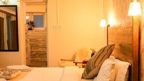 A hotel room with a bed, a nightstand, a lamp, and a wooden headboard. - Horzay stays - Single Room with Mountain View - 3 (Leh)