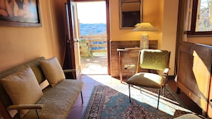 Una habitación acogedora con sofá, sillón, aparador de madera y vistas al exterior.