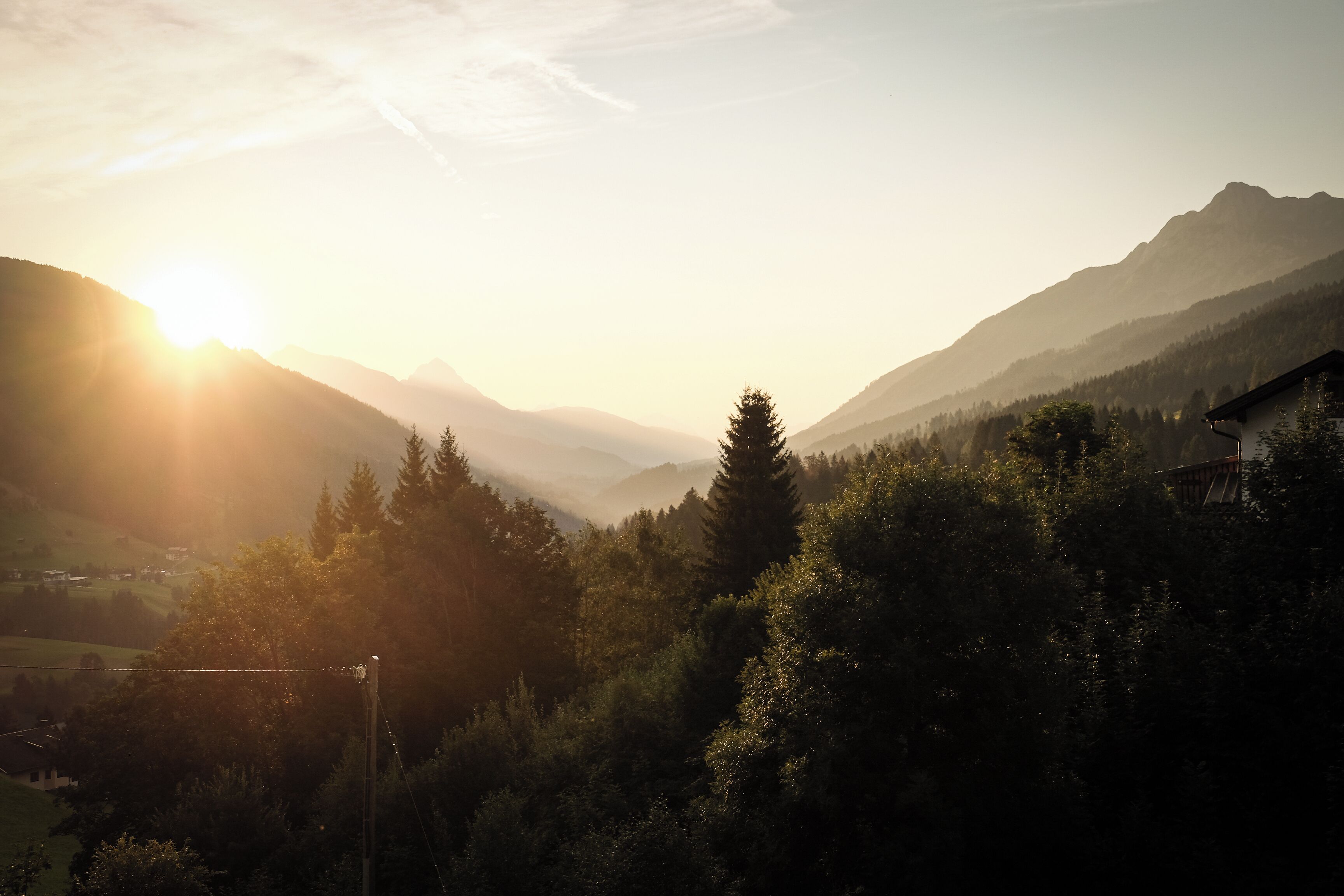 Paesaggio montuoso con cielo sereno e luce solare.