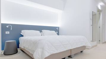 Um quarto moderno com cama, mesas de cabeceira e luminária na parede.