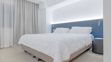 Quarto moderno com cama, cortinas e mesa de cabeceira.