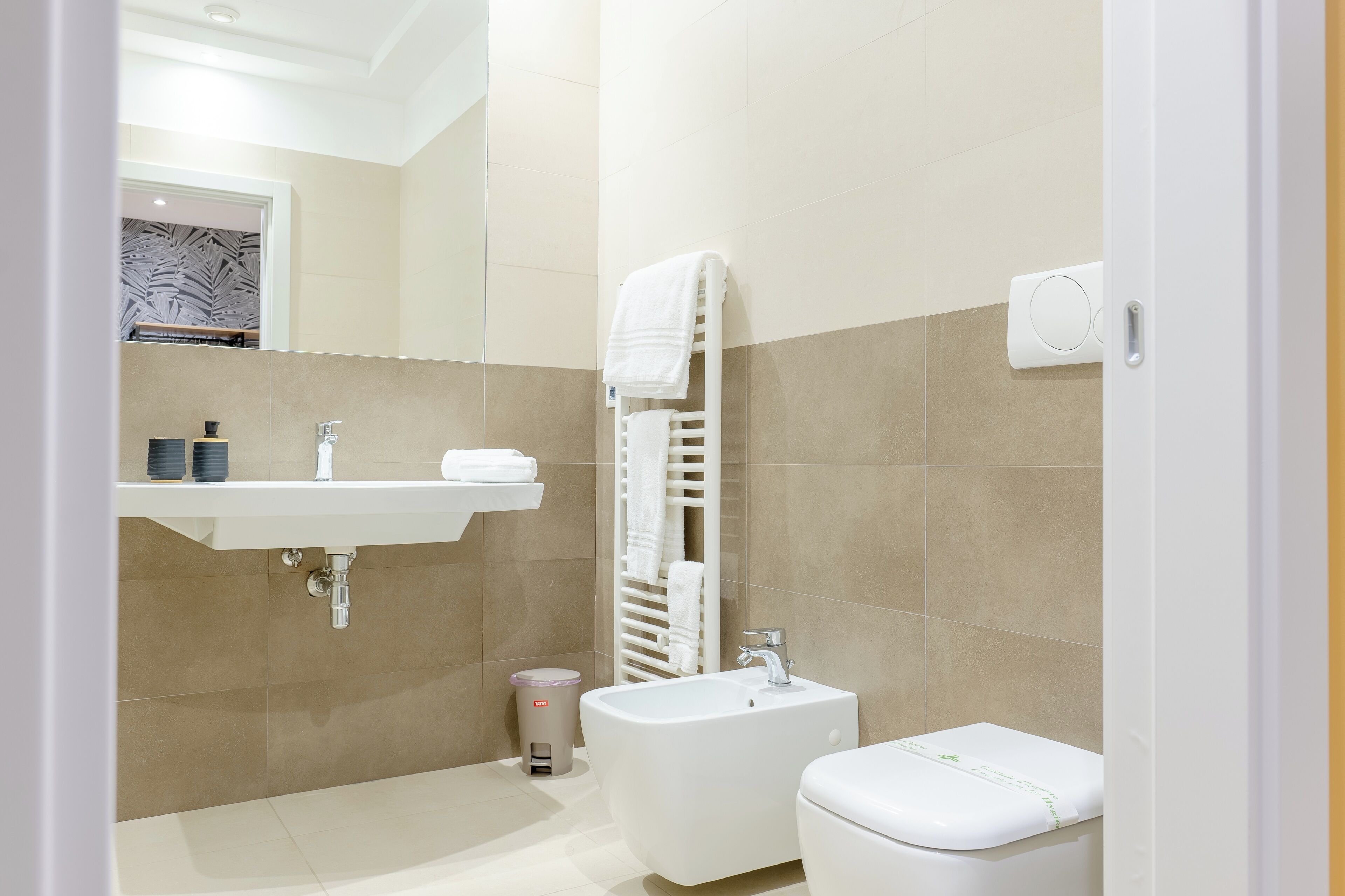 A modern bathroom with a sink, toilet, and bathtub.