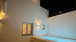 A modern outdoor area with a pool, steps, and wall-mounted lights. - Ios Alcyon Blue Suites (Ios)