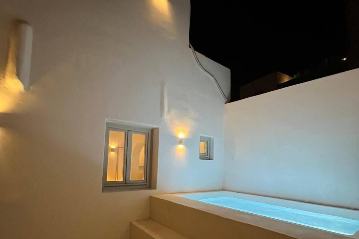 A modern outdoor area with a pool, steps, and wall-mounted lights.