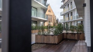 Un immeuble d’appartements moderne, avec le clocher d’une église traditionnelle en arrière-plan.