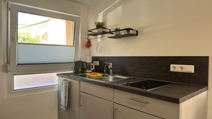 Een moderne keuken met een raam, inbouwkasten, een spoelbak en een aanrecht.