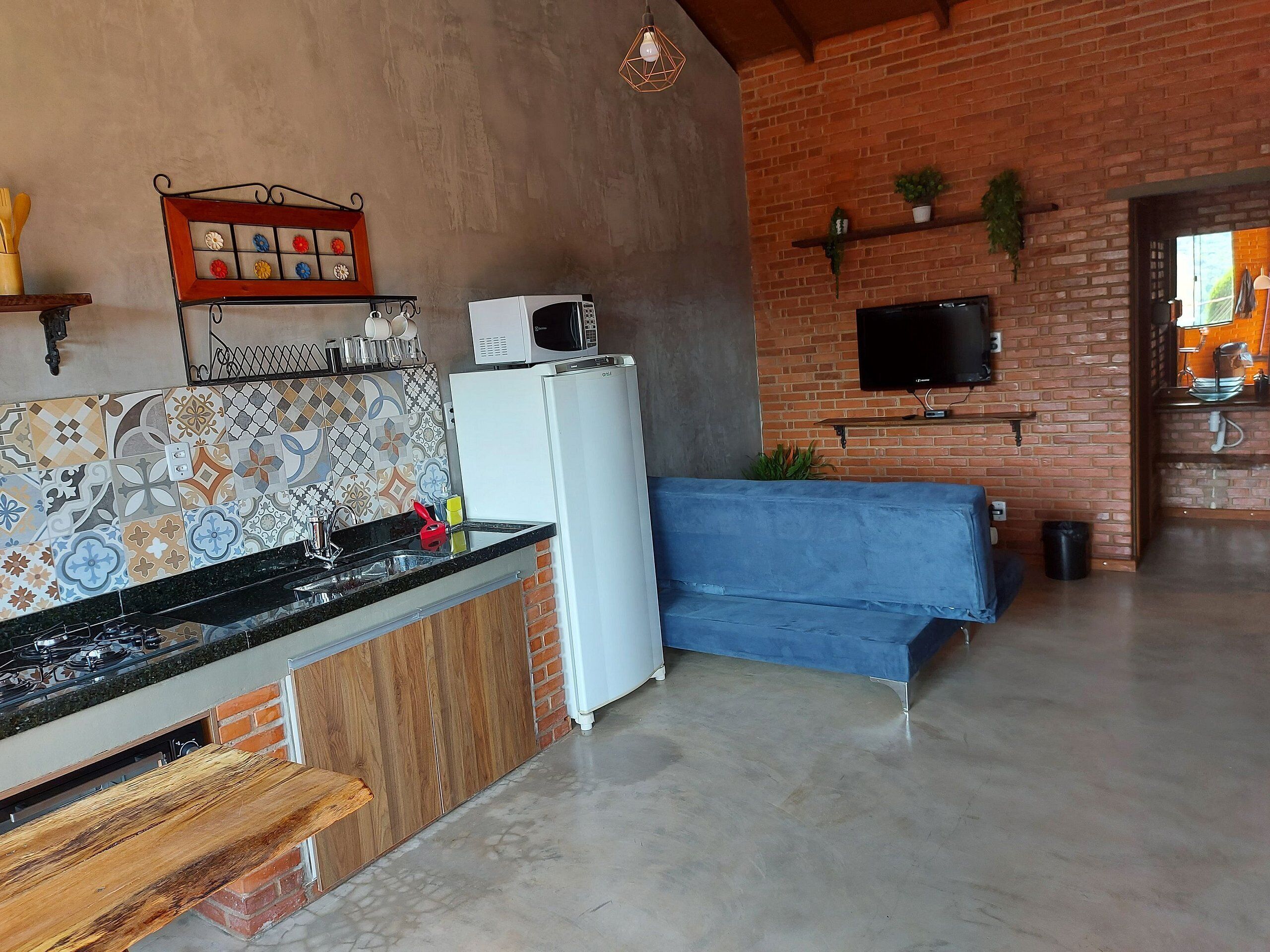 Una cocina moderna con estufa a gas, refrigerador blanco y sofá azul.