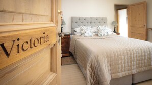 Ein Schlafzimmer mit einem großen Bett, einem Nachttisch, einer Lampe und einem Kleiderschrank.