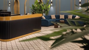 Un'area di accoglienza con un bancone curvo, posti a sedere e un soffitto decorativo.