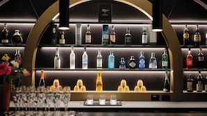Angolo bar con scaffali pieni di bottiglie di liquori e bicchieri.