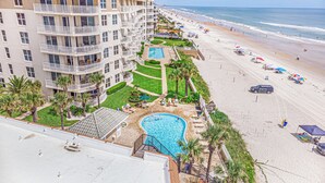 Um hotel com piscina, acesso à praia e vista para o oceano.