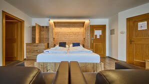 Ett hotellrum med en väggpanel av trä, en säng med kuddar, en bänk och en dörr av trä.