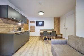 A compact living space with a kitchenette, a dining area, and a seating area.