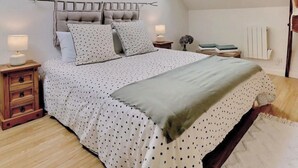 Une chambre à coucher avec un lit, une table de chevet, une lampe, un radiateur et une fenêtre.