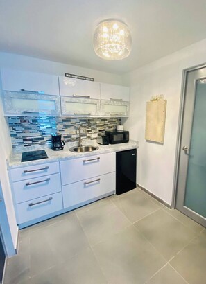 Fully equipped kitchen with a stainless steel sink, coffee maker, microwave, and dishwasher.