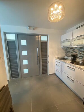 Modern kitchen with oven, microwave, and stainless steel sink.