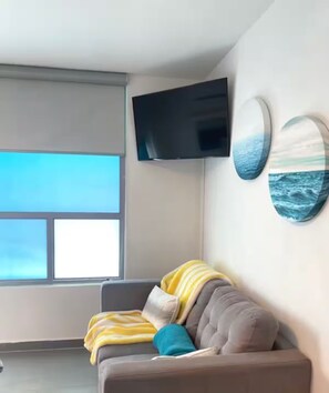 Relax in this stylish living room with a sofa, flat-screen TV, and ocean views.