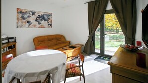 Een kamer met een bed, een slaapbank, een eettafel en uitzicht op de omgeving.