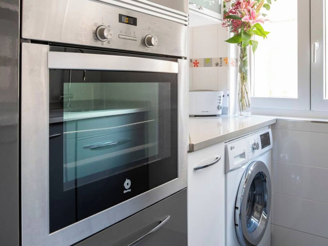 Eine moderne Küche mit Backofen und Waschmaschine.