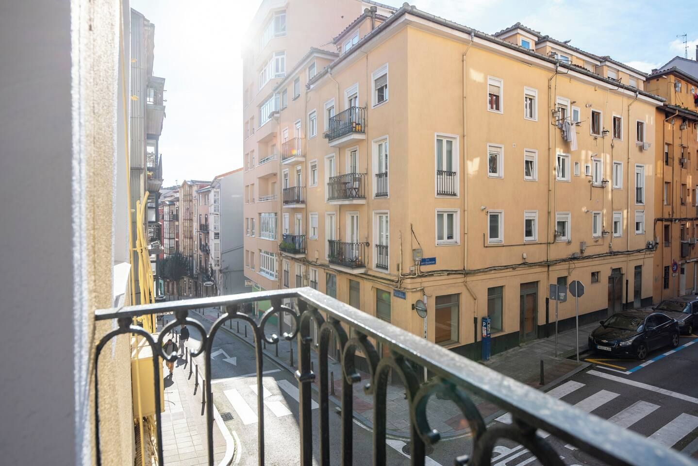 Un balcón con vista a una calle y edificios.