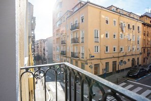 Een balkon met uitzicht op een straat en gebouwen.