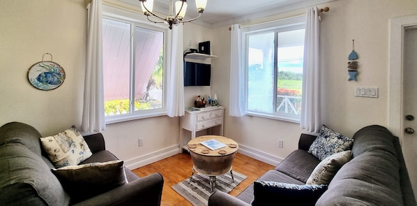 A living room with two sofas, a coffee table, and a small side table.