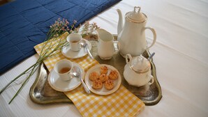 A tray with a tea set, including a teapot, cups, and saucers, arranged on a checkered napkin. - Nine Rooms Suites (Trento)
