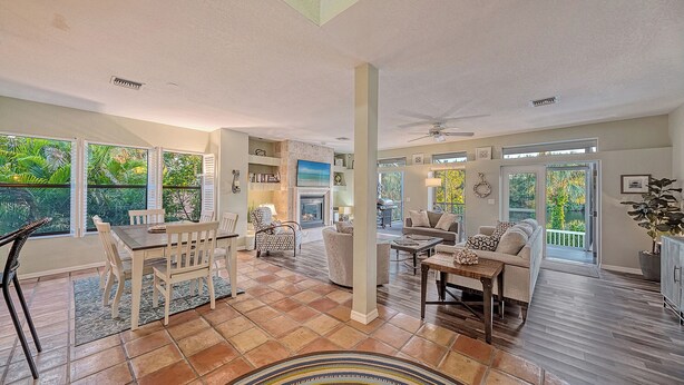 A spacious living area with a fireplace, comfortable seating, and large windows offering views of the outdoors. - Siesta Key Complete House - Pool - Jacuzzi - 3 Bedroom - 2 Bath - Screened Patio (Sarasota)