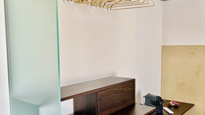A modern room with a wooden dresser, a glass partition, and a wooden shelf with a hanging rack. - La Piazzetta, Luxury Charming Balcony Room, a few steps from the beach  (Polignano a Mare)
