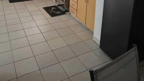 Eine Küche mit Holzausstattung, einem Edelstahl-Kühlschrank, einer Mikrowelle und einem Herd.