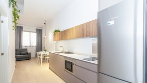 A modern kitchen with a Bosch refrigerator, wooden cabinets, and a built-in oven. - GuestReady - Cozy stay near Malvarrosa Beach (Valencia)