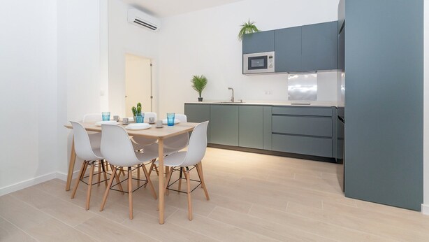 Une cuisine moderne avec des meubles gris, un four à micro-ondes et un évier.