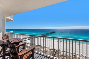 Un balcon avec vue sur l’océan et une jetée.