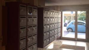 A hallway with a row of lockers on the left and a door leading outside. - Air-conditioned studio 2 min from the beach - Centre Juan-les-Pins (Antibes)