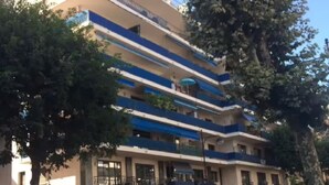 A multi-story hotel with balconies, a parking area, and a pedestrian walkway. - Air-conditioned studio 2 min from the beach - Centre Juan-les-Pins (Antibes)
