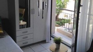 A small, modern bedroom with a bed, a wardrobe, and a balcony with a view of the outside. - Air-conditioned studio 2 min from the beach - Centre Juan-les-Pins (Antibes)