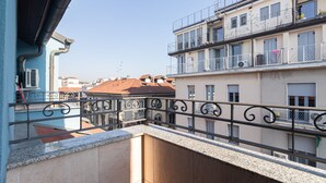 A balcony with a metal railing, a view of neighboring buildings, and a clear sky. - Italianway - Rosmini 11 B (Milan)