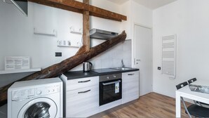 A compact kitchen with a washing machine, a stove, and a sink. - Italianway - Rosmini 11 B (Milan)