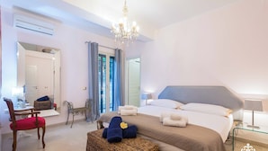 A bedroom with a large bed, a chair, a small table, and a mirror. - Villa Festosa - Luxury Retreat  (Santa Croce Camerina)