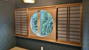 A traditional Japanese room with tatami flooring, a shoji screen, and a hanging lantern. - Kamogawa House- Exquisite two-story home with a japanese garden (Kyoto)