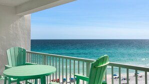 A balcony with a view of the ocean, a table, and two chairs. - Shoreline Towers 1073 (Destin)