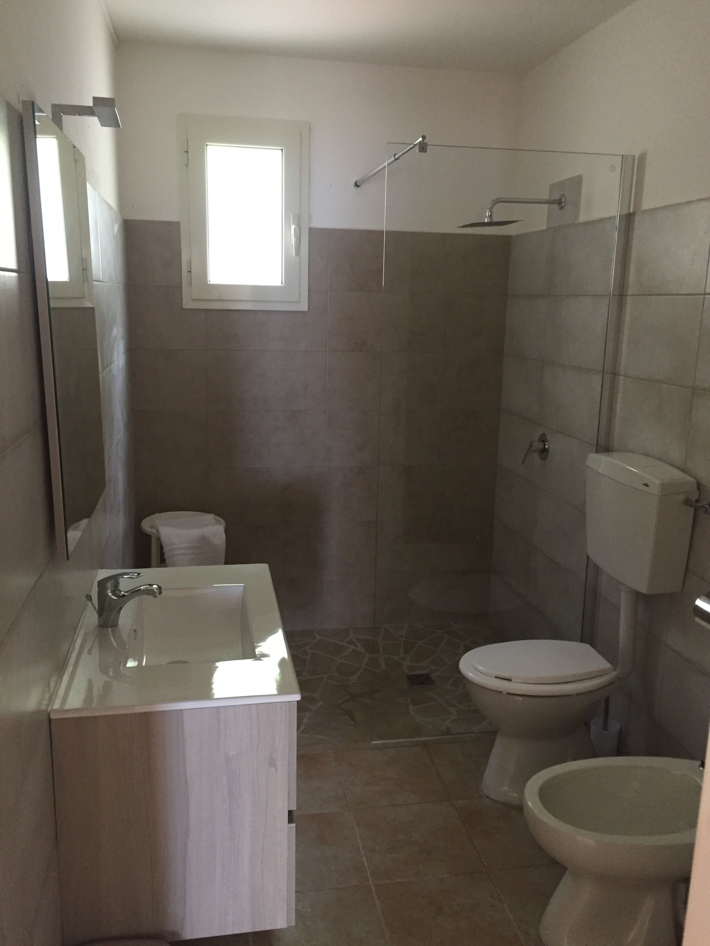 A bathroom with a sink, toilet, and shower.