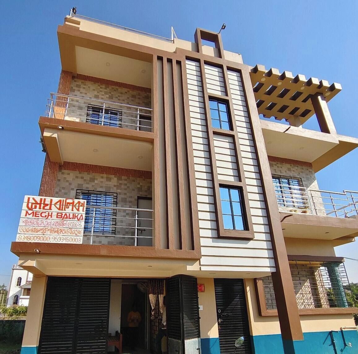 A multi-story building with a signboard advertising a business.